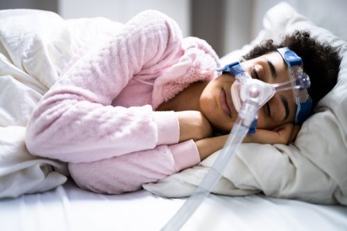 woman sleeping with a CPAP machine